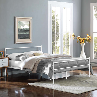 White metal bed frame with gray and beige bedding in a blue-gray bedroom, beside a wooden nightstand and sunflowers.