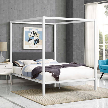 White four-poster canopy bed frame with gray upholstered headboard in a modern bedroom; geometric art, nightstand, rug.