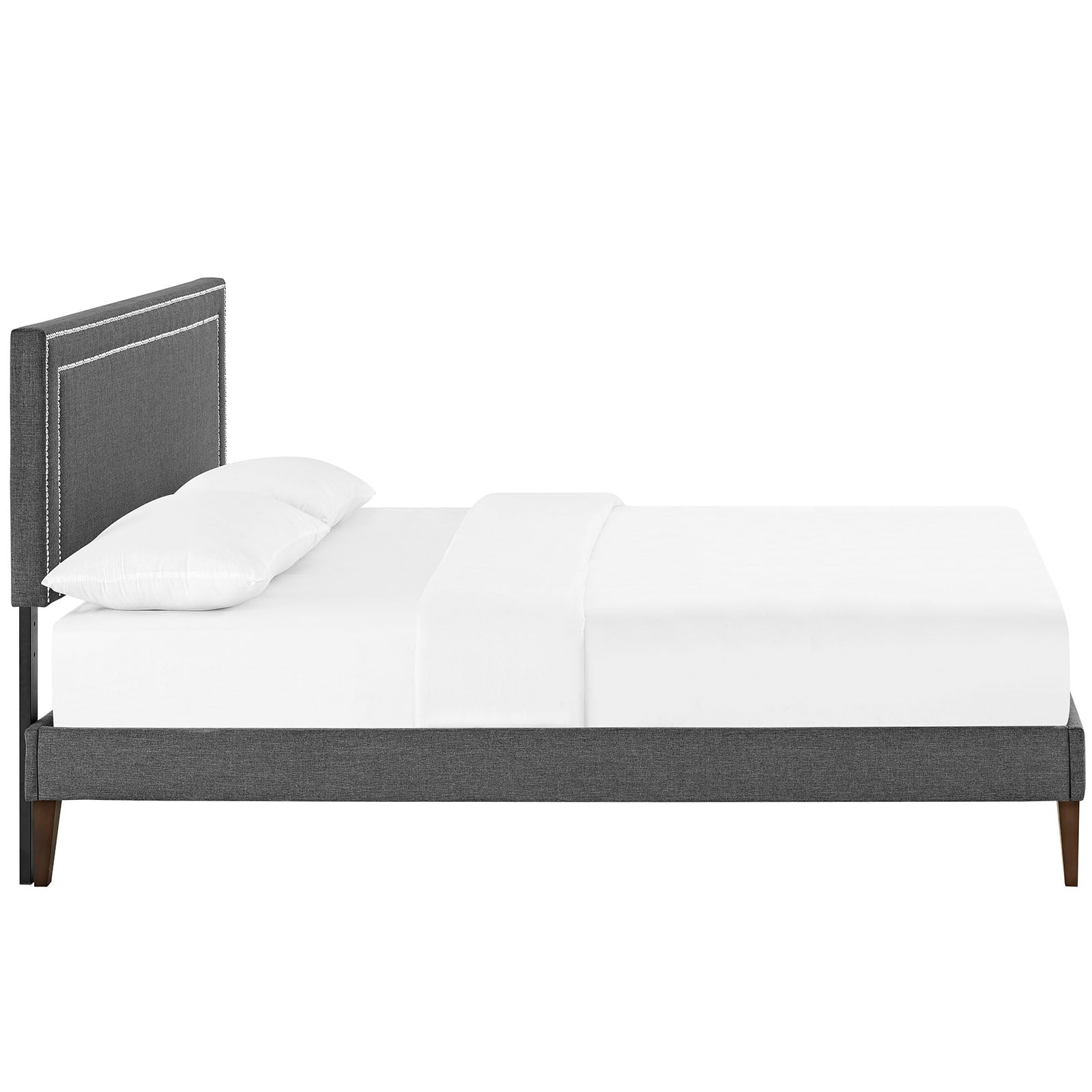 Gray upholstered platform bed with tall stitched headboard, white bedding, and tapered wooden legs.