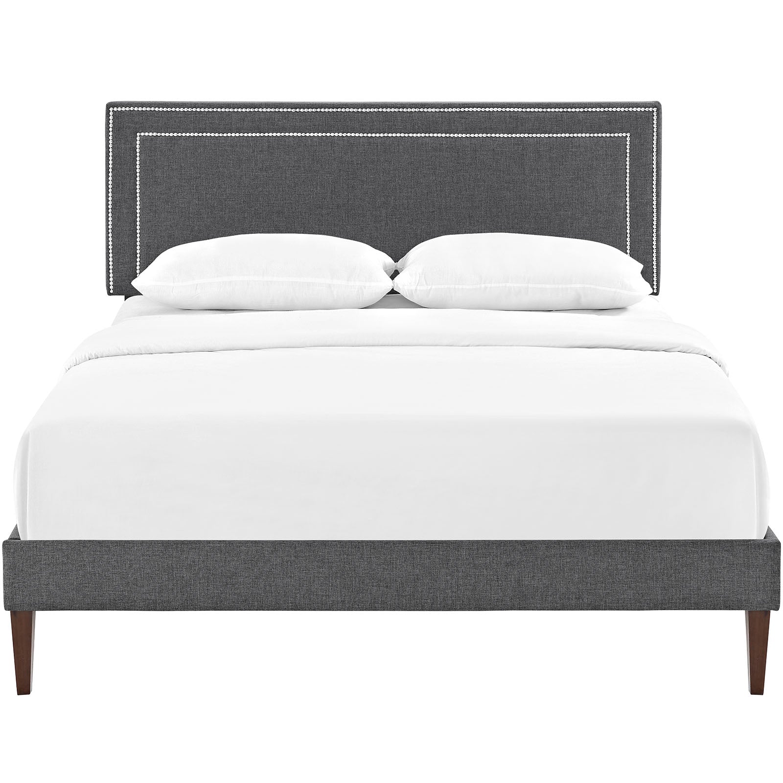 Gray upholstered platform bed with nailhead-trim headboard, white bedding, and squared tapered legs.