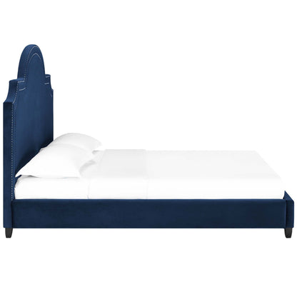 Navy blue upholstered bed with tall curved headboard and white bedding.