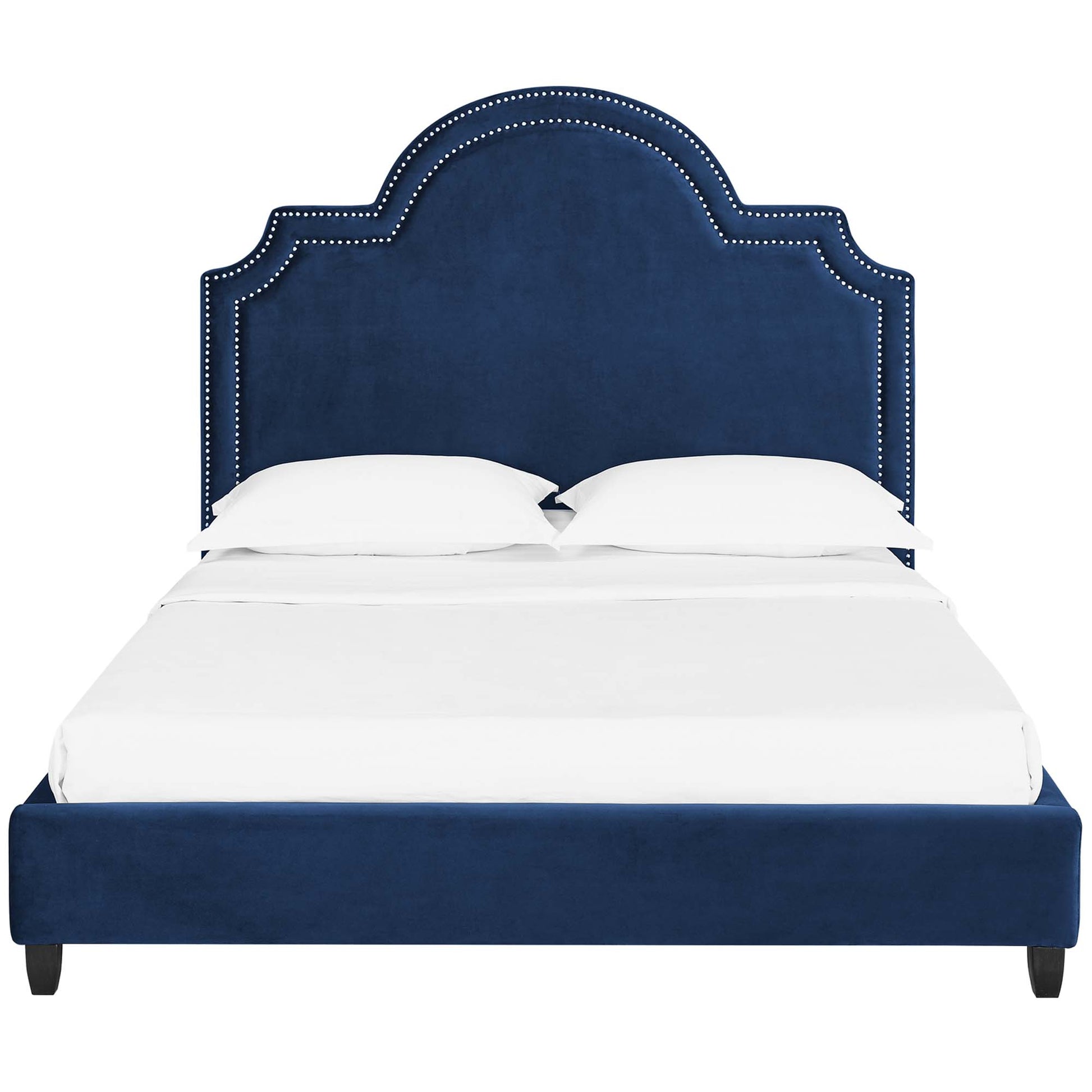 Navy blue velvet upholstered bed with a double-arched, nailhead-studded headboard & matching footboard, white bedding.
