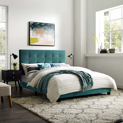 Teal tufted upholstered bed with white grid duvet, teal throw, dark wood nightstands, abstract wall art, beige shag rug.