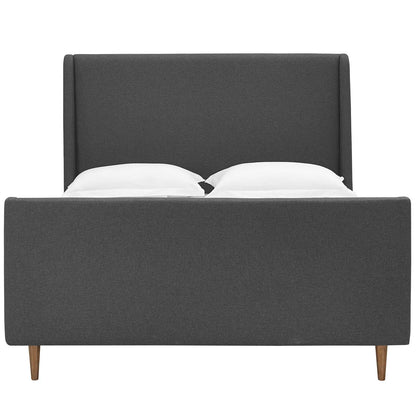 Grey fabric upholstered platform bed with tall headboard, low footboard, tapered wooden legs, and two white pillows.