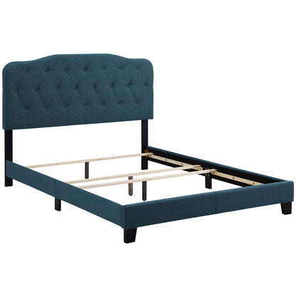 Azure upholstered bed with tufted curved headboard, dark legs, and wooden slat support for mattress.