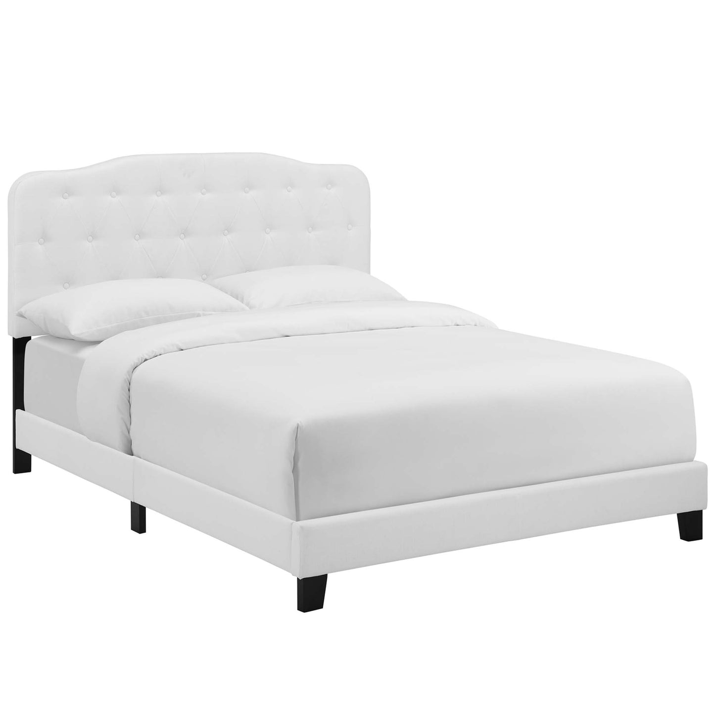 White fabric upholstered king bed with tufted curved headboard, low platform frame and black legs.