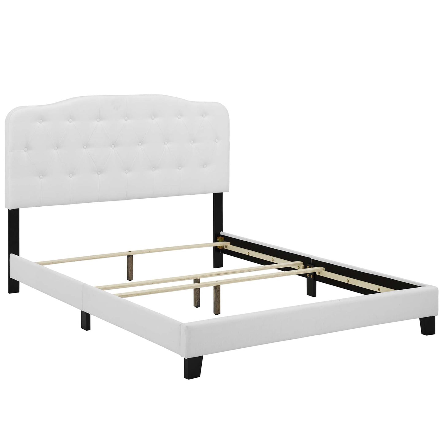 White tufted upholstered king bed with black legs and exposed wooden slat supports.