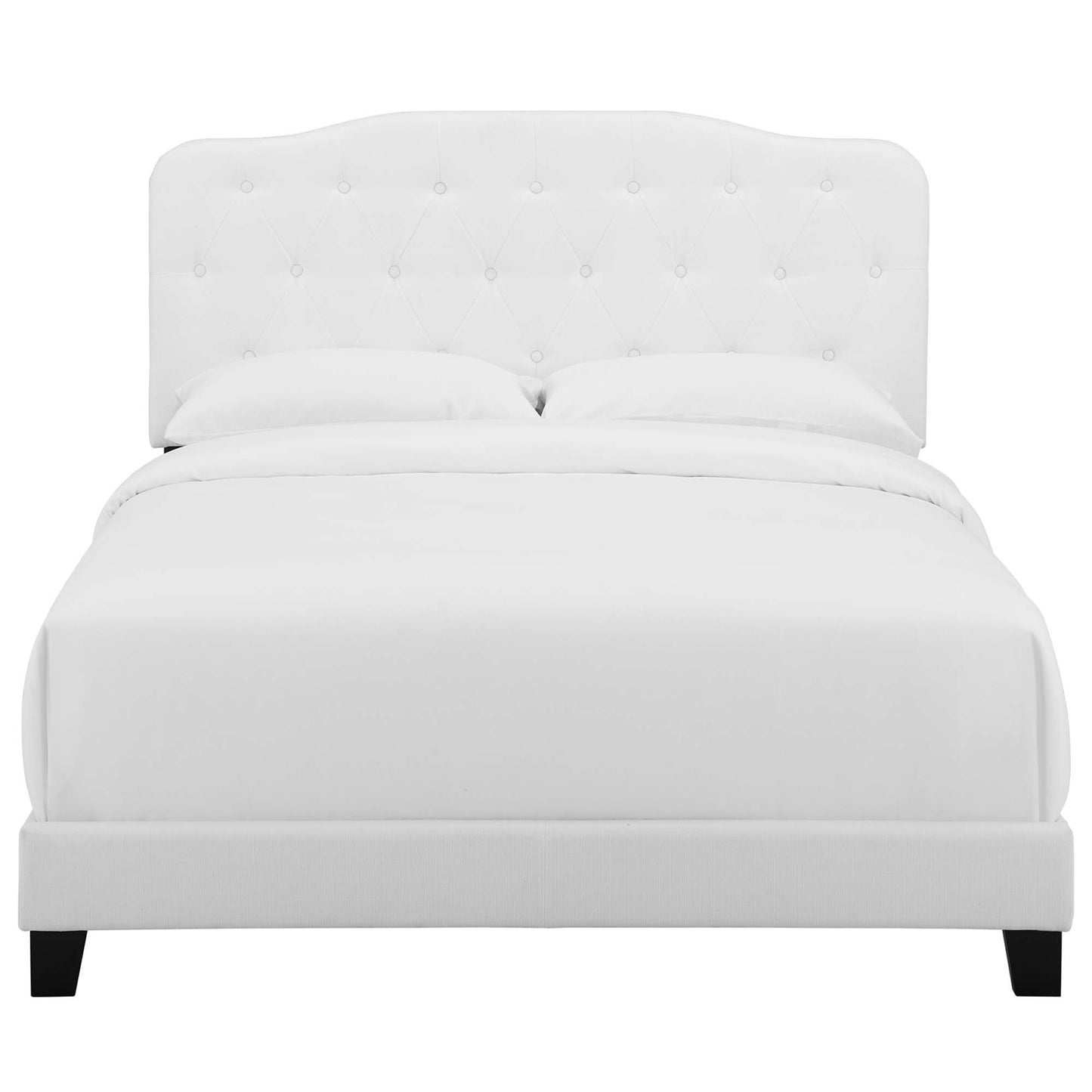 White tufted headboard bed with clean platform frame and dark legs; modern bedroom centerpiece.