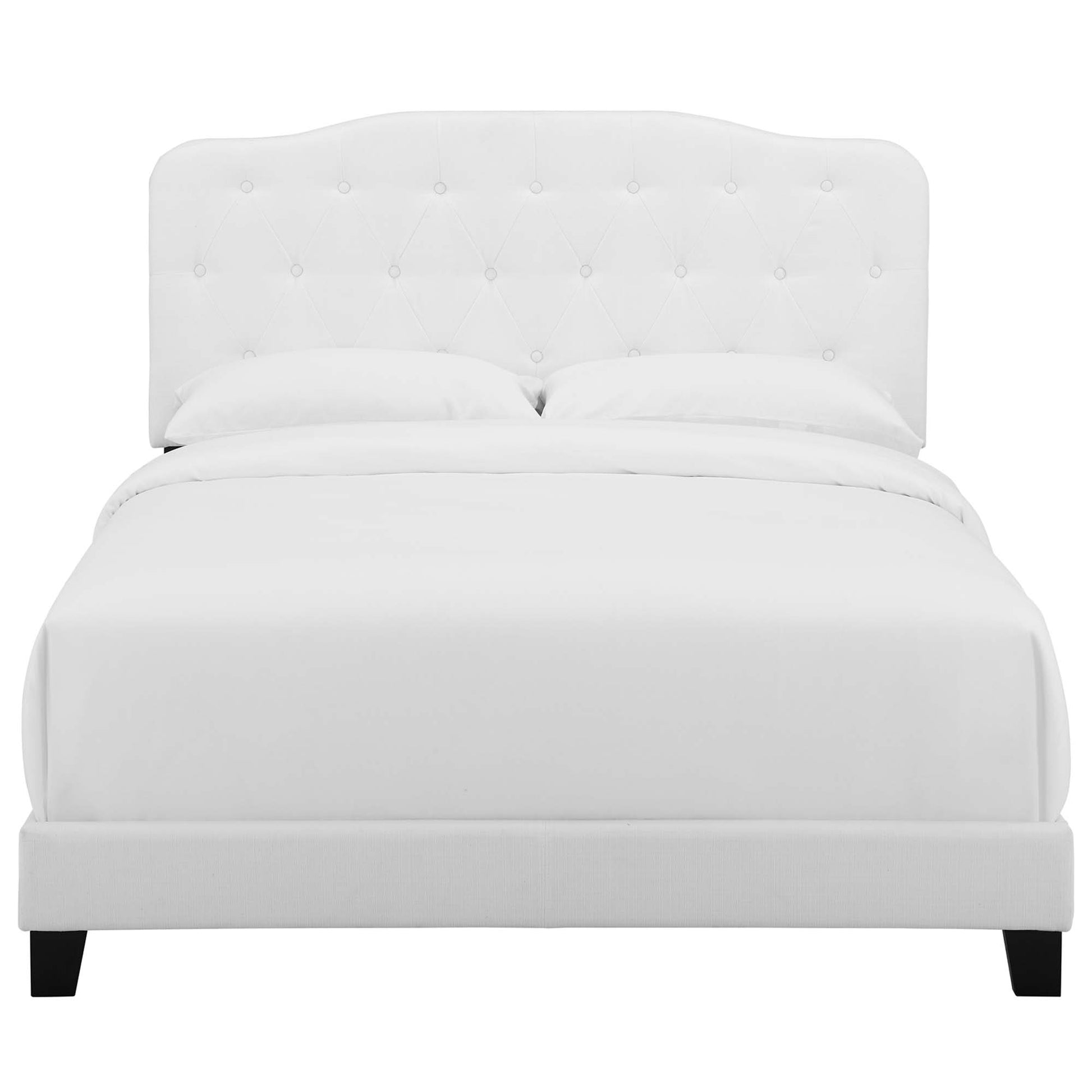 White tufted headboard bed with clean platform frame and dark legs; modern bedroom centerpiece.