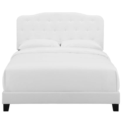 White tufted headboard bed with clean platform frame and dark legs; modern bedroom centerpiece.