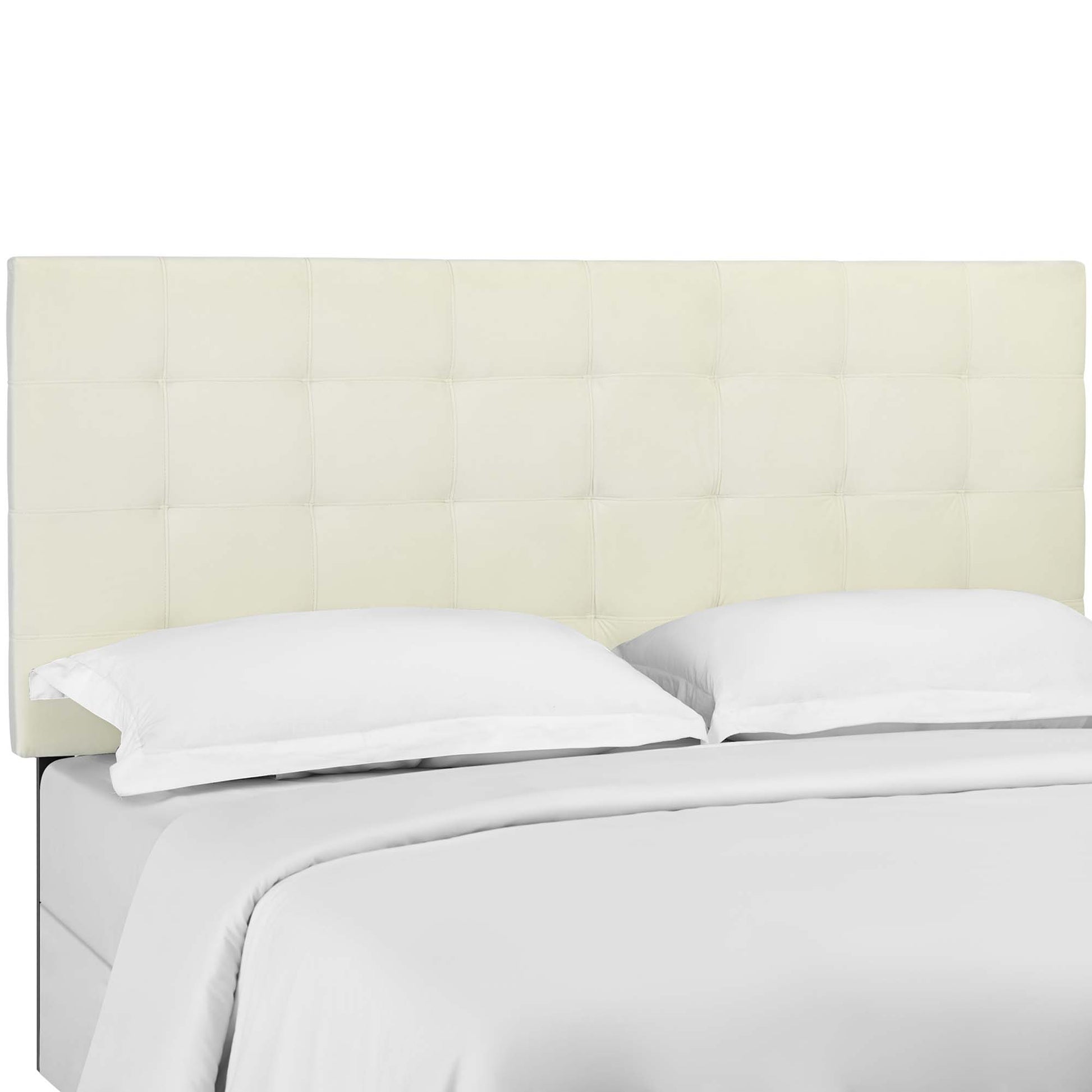 Ivory tufted headboard with square panels, white sheets and two white pillows on bed.