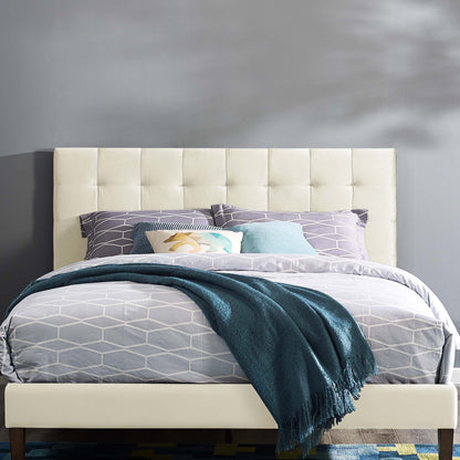 Ivory tufted upholstered headboard with a cushioned panel, shown with gray geometric bedding, teal throw, and lavender and aqua pillows.