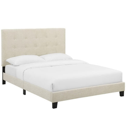 Beige upholstered bed with tufted headboard, low platform frame, black legs & white bedding.