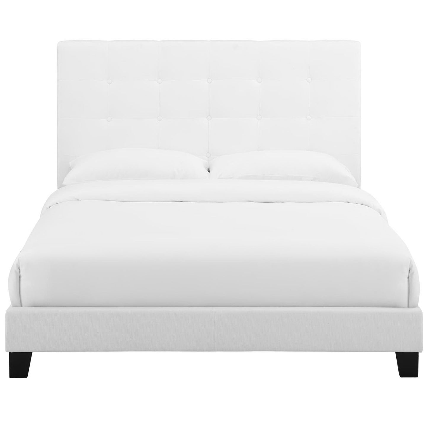 White tufted upholstered bed with tall headboard and low platform frame, dressed in white bedding.