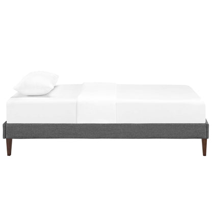 Gray upholstered platform bed frame with tapered wooden legs and white bedding.