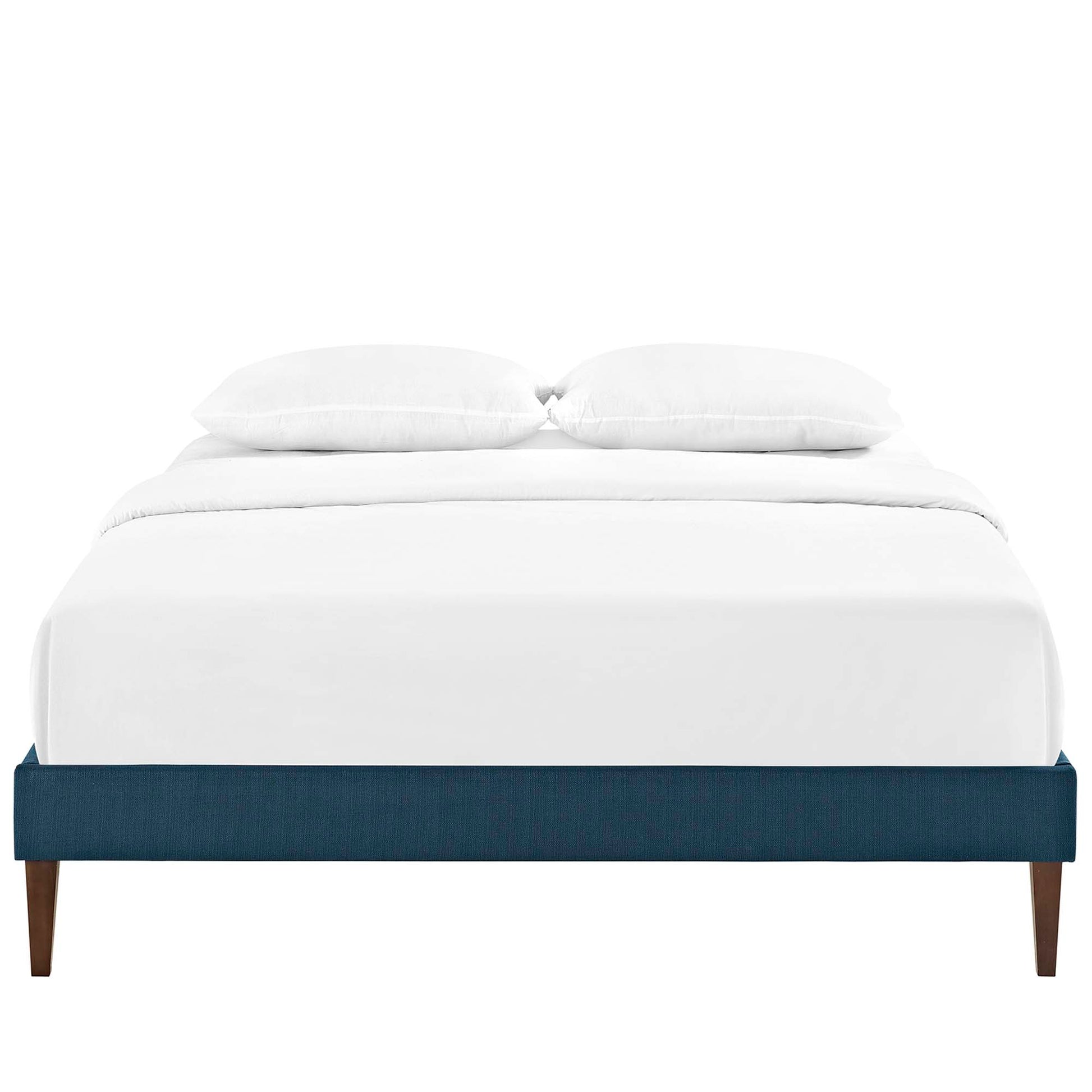 Low-profile navy blue upholstered platform bed with white bedding and two pillows, wooden tapered legs.