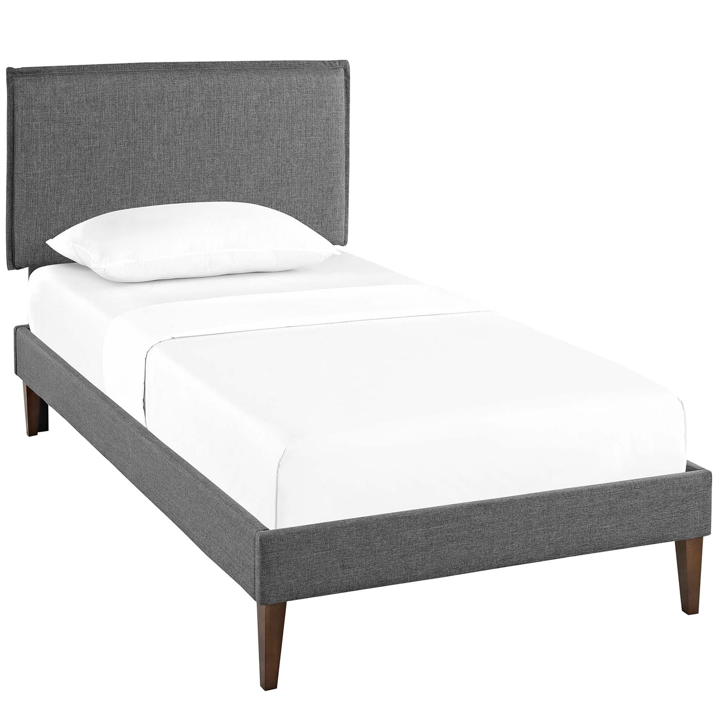 Grey upholstered twin bed frame with matching headboard, white linens, and tapered wooden legs.