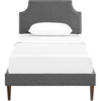 Gray fabric platform bed with squared tapered legs and white bedding.