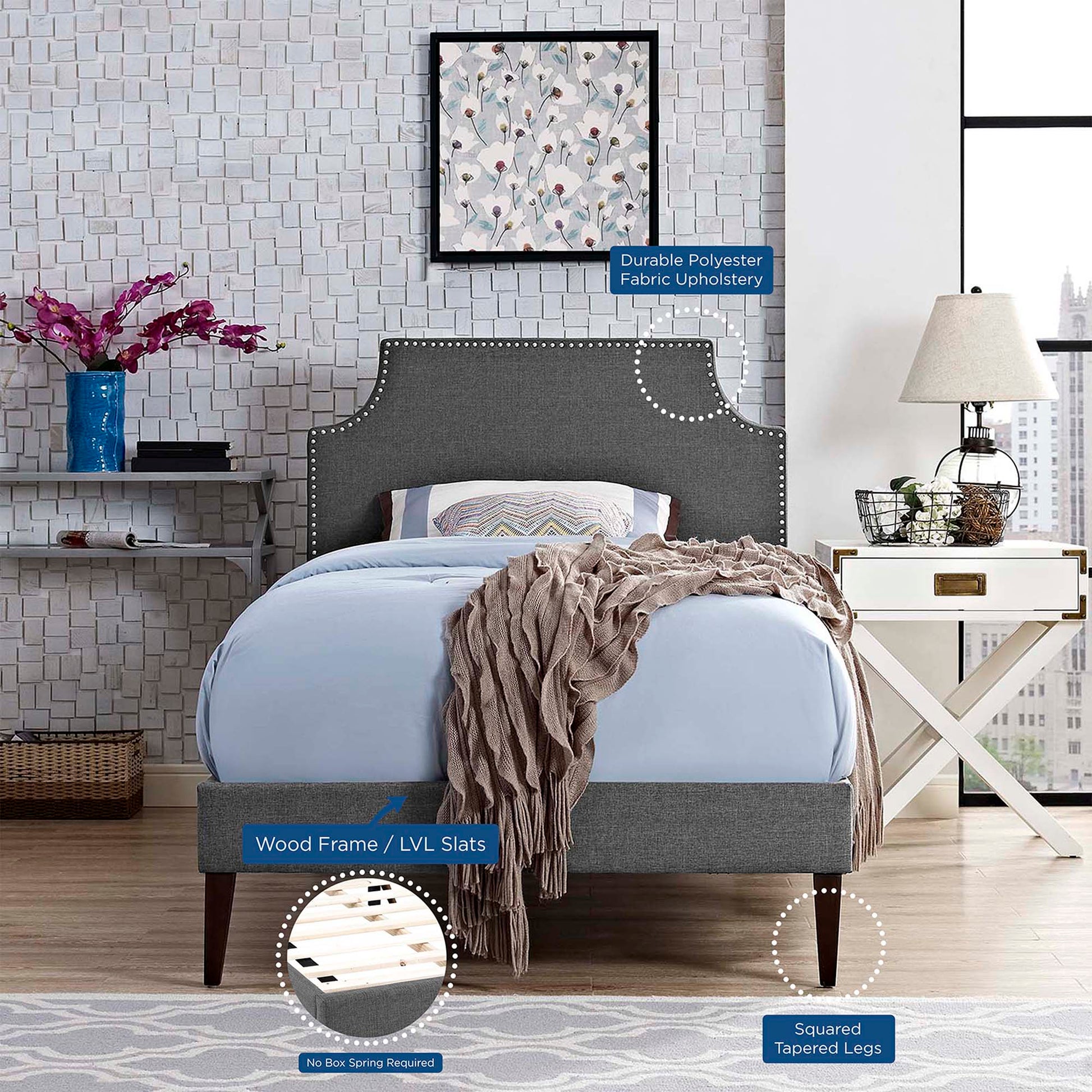 Grey fabric twin platform bed with squared tapered legs and LVL slats; blue bedding and cozy throw