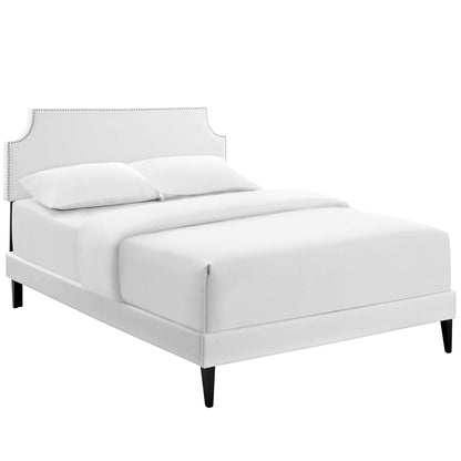 White vinyl queen platform bed with squared tapered legs.