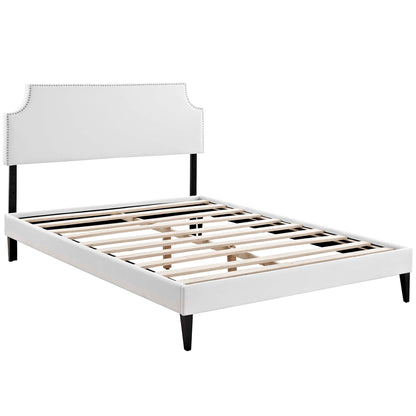White vinyl queen platform bed with squared tapered legs.