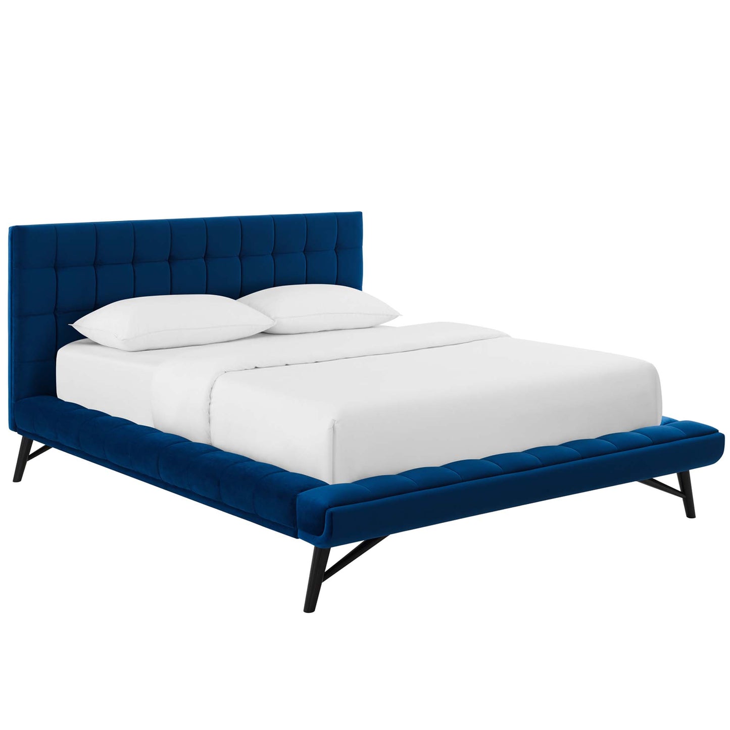 Navy velvet tufted platform bed with tall square headboard, low upholstered edges, black angled legs, white bedding.