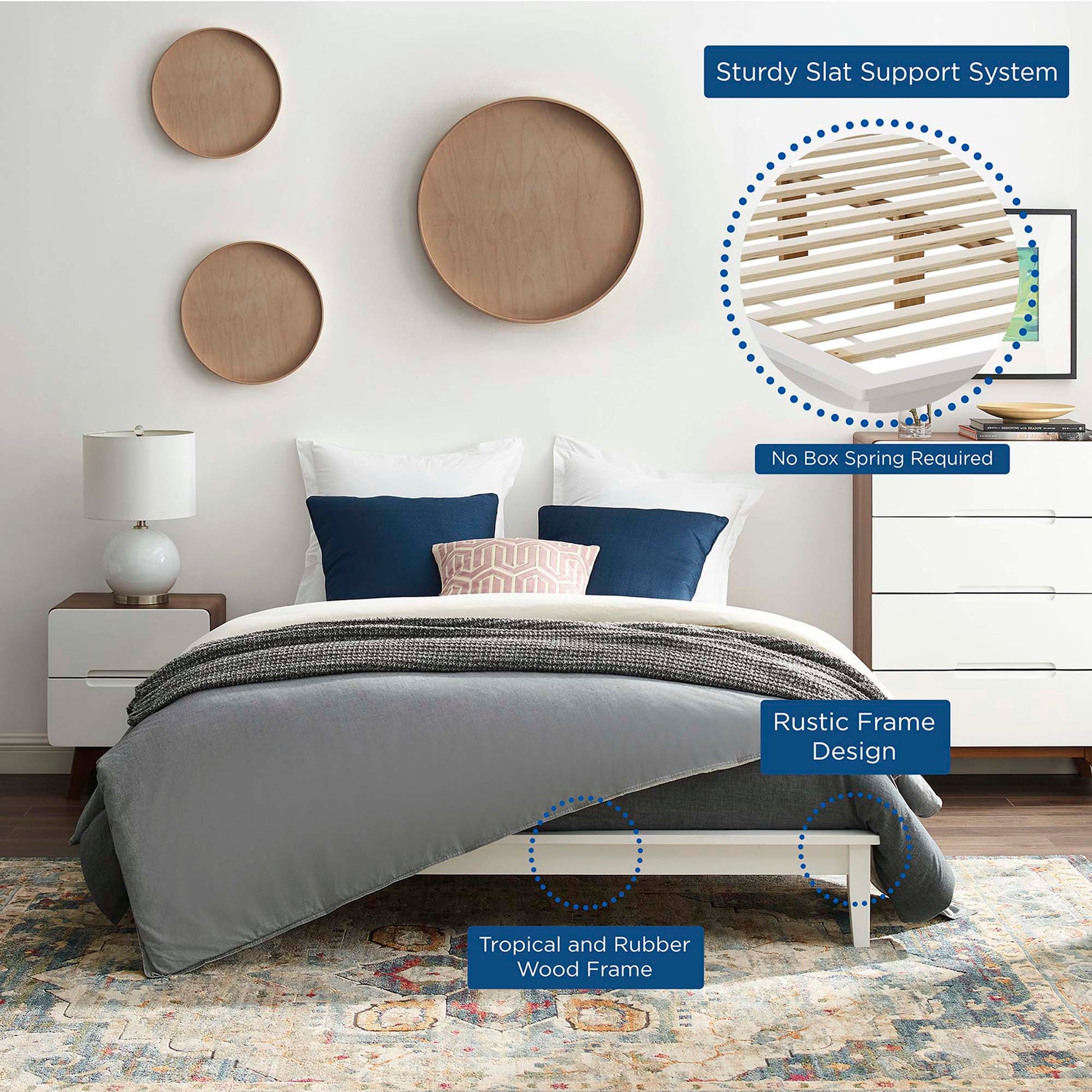 Low-profile white platform bed with rustic rubber wood frame and slat support; gray bedding with navy pillows.