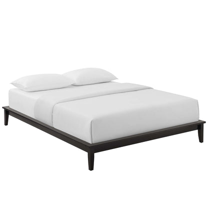 Minimalist dark wood platform bed with a low frame, tapered legs, and white bedding with two pillows.