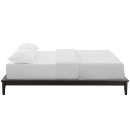 Low-profile dark wood platform bed with white bedding and two pillows, minimalist modern design.