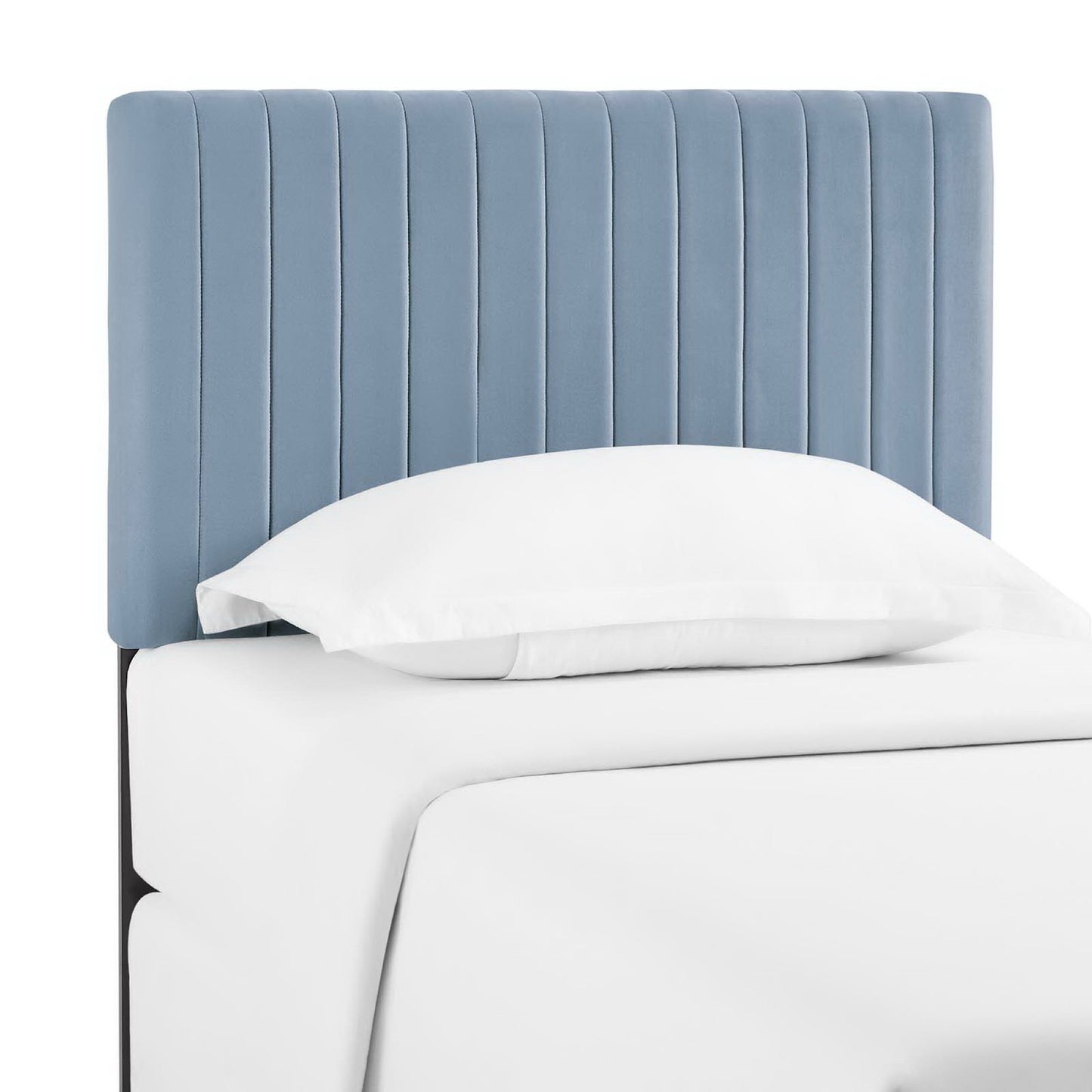Blue fabric vertical-channel upholstered headboard on a white bed with crisp white sheets.