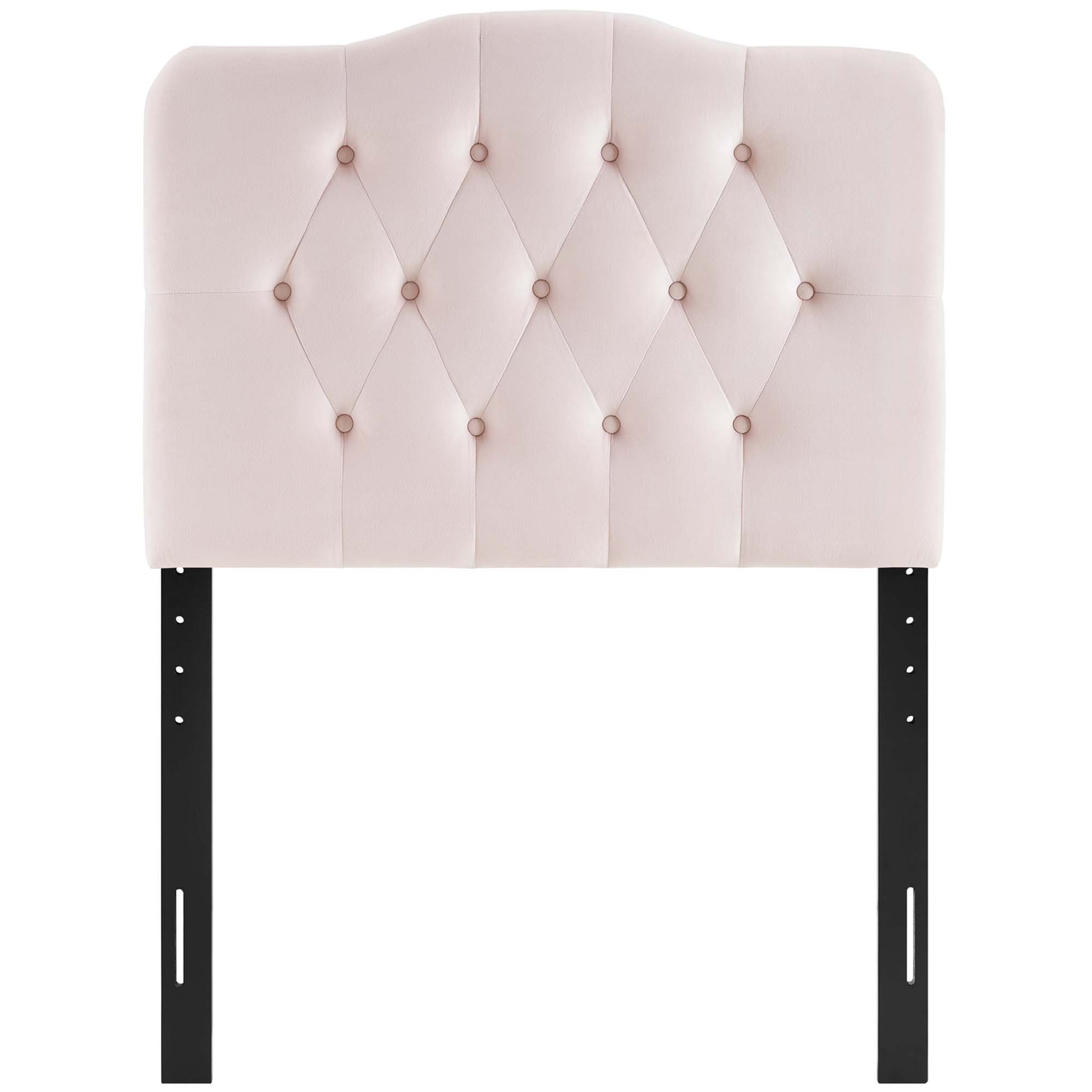 Blush pink velvet headboard with diamond button tufting on a curved top, supported by black metal legs.