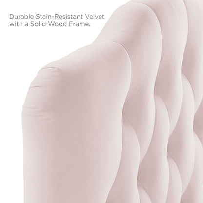 Close-up of pale pink velvet tufted headboard with curved, padded panels and a solid wood frame.