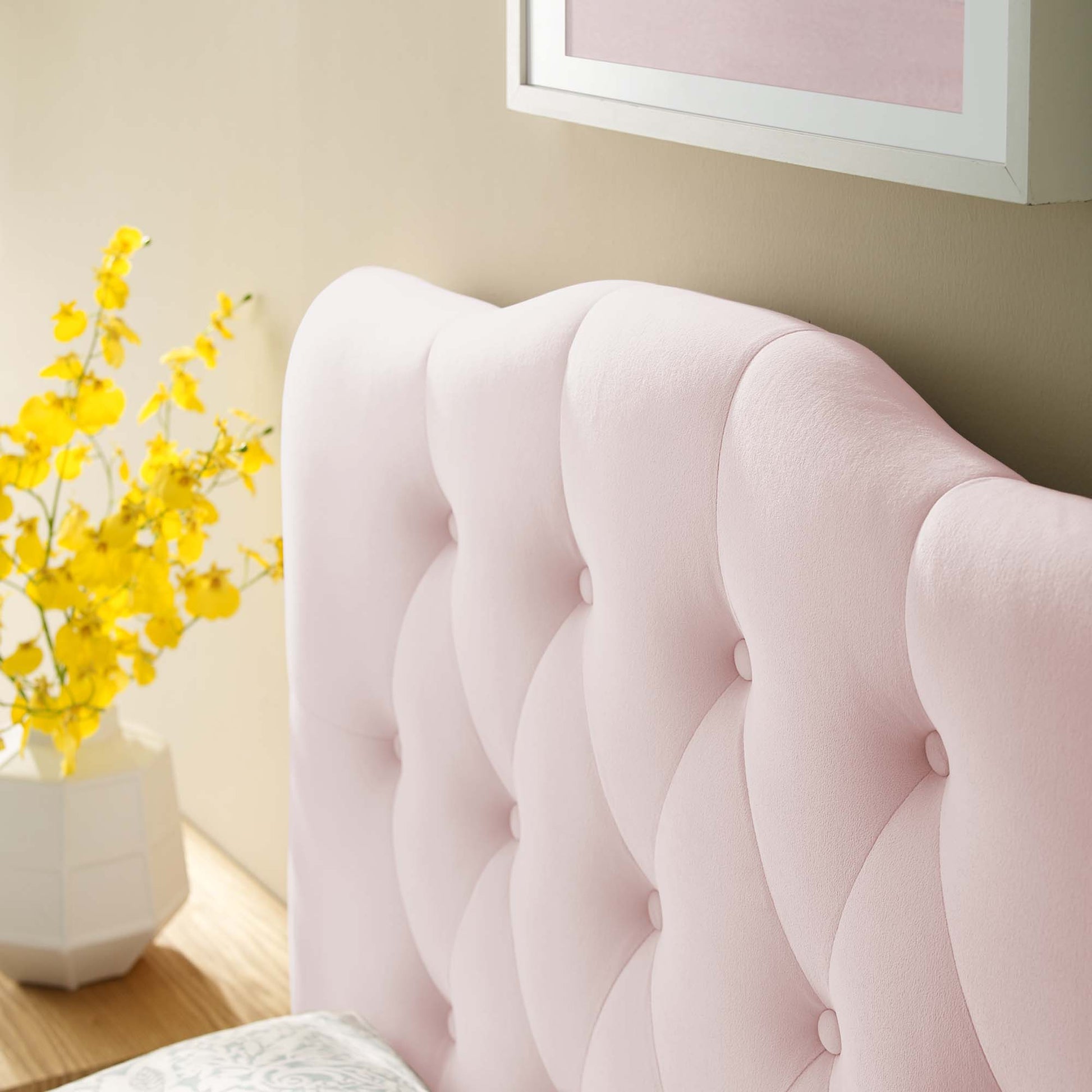 Soft pink velvet headboard with diamond-tufted upholstery and curved wings for a chic bedroom look.