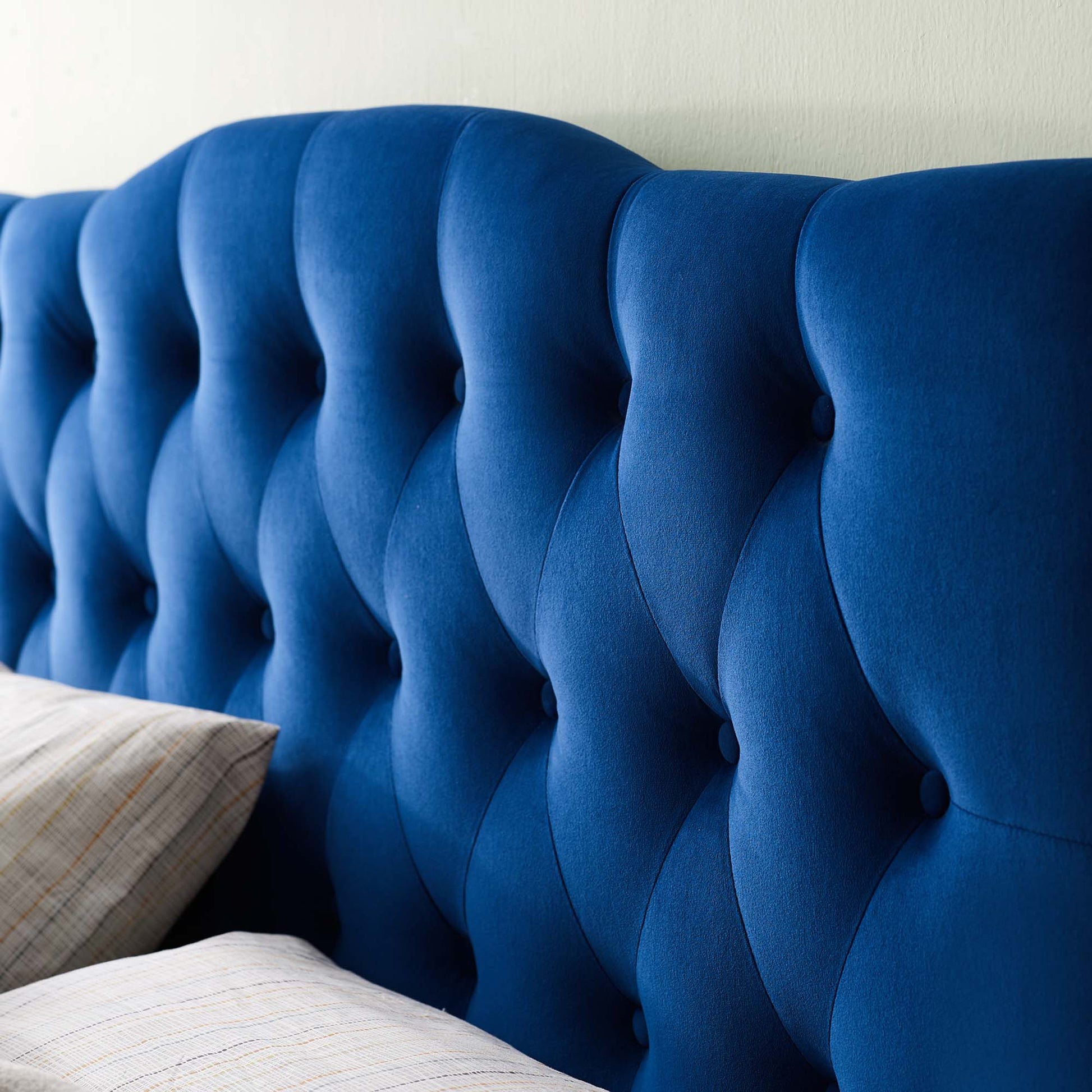 Royal blue velvet diamond-tufted headboard with curved panel design, queen size, paired with light plaid pillows.