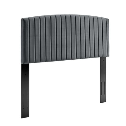 Gray ribbed upholstered twin headboard with vertical channels, curved top, mounted on slender metal legs.