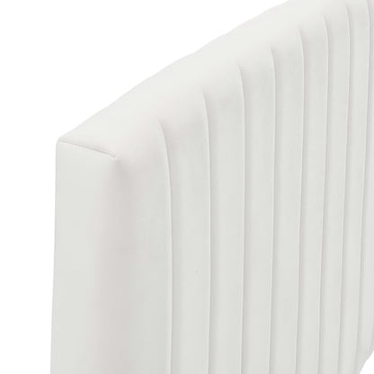 White curved-back upholstered twin headboard with vertical channel tufting.