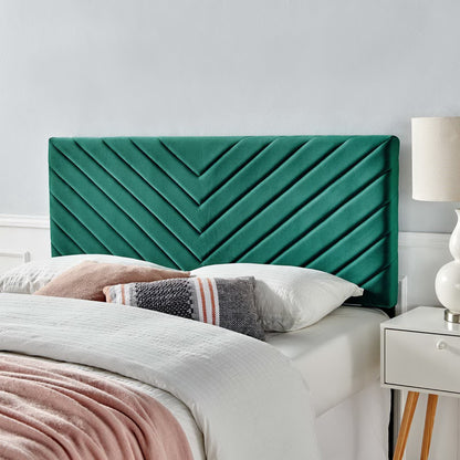 Blue velvet twin headboard with angular channel tufting on a bed with white linens and a pink throw.