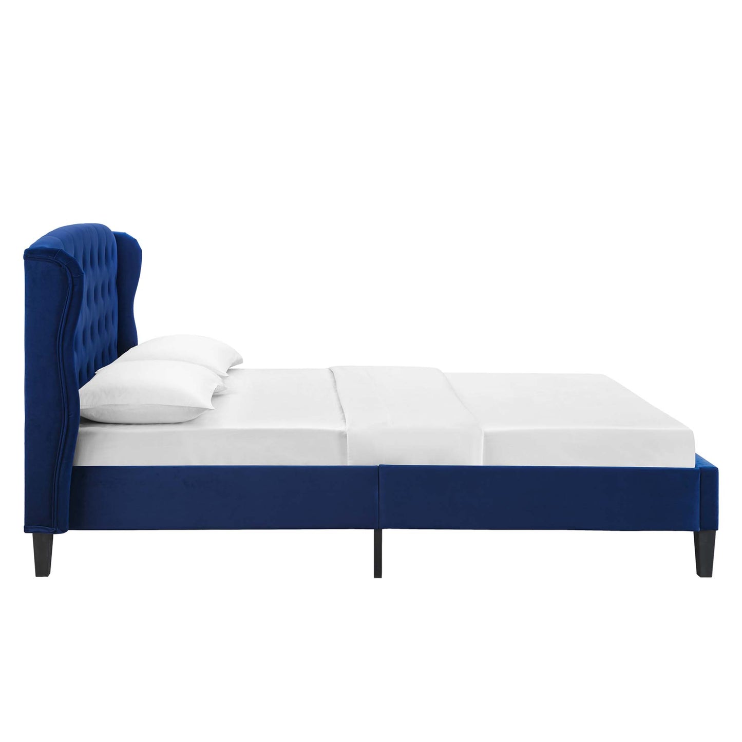 Navy blue upholstered platform bed with a tall tufted headboard and white bedding on black legs.