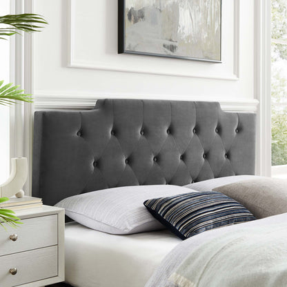 Charcoal-gray tufted headboard with diamond buttons, white bedding, striped navy pillow, white nightstand.