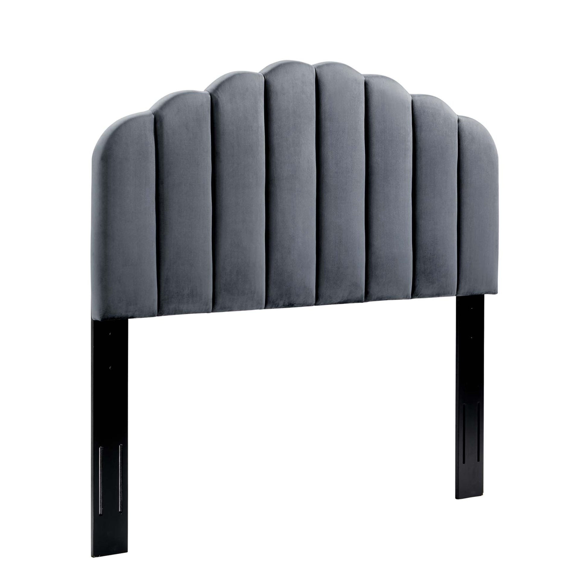 Gray velvet upholstered headboard with scalloped arched top and vertical channel tufting, supported by black legs.