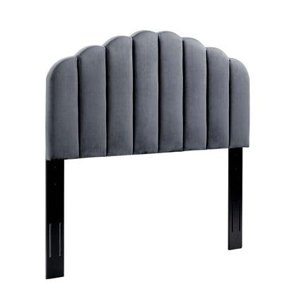 Gray velvet upholstered headboard with scalloped arched top and vertical channel tufting, supported by black legs.