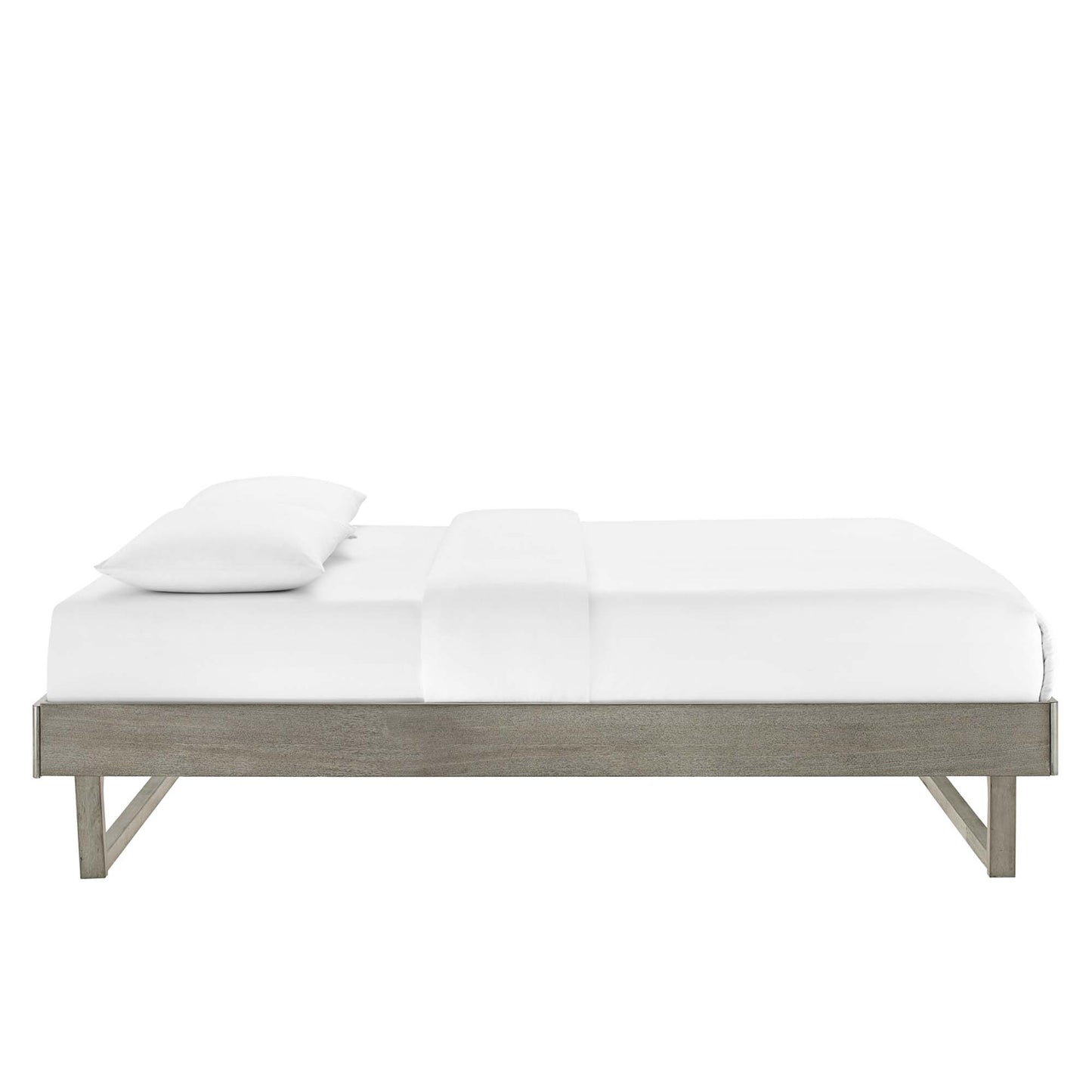Low-profile grey wood platform bed with a minimalist frame and white bedding, single white pillow.