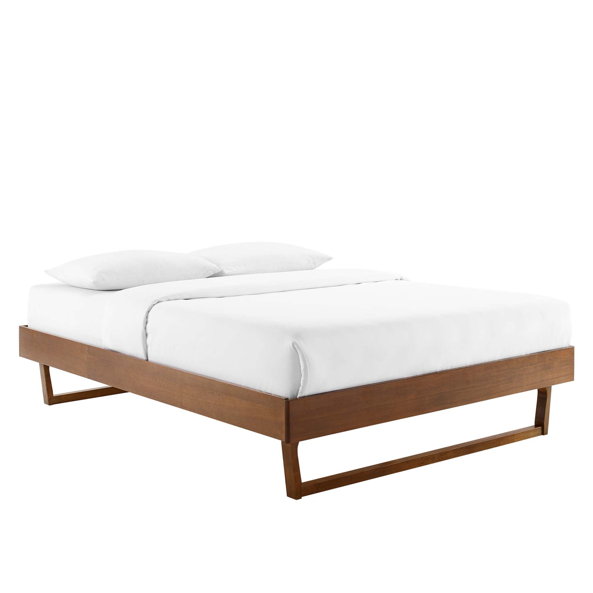Walnut platform bed with a low-profile rectangular frame & open base, dressed with a white mattress & pillows.