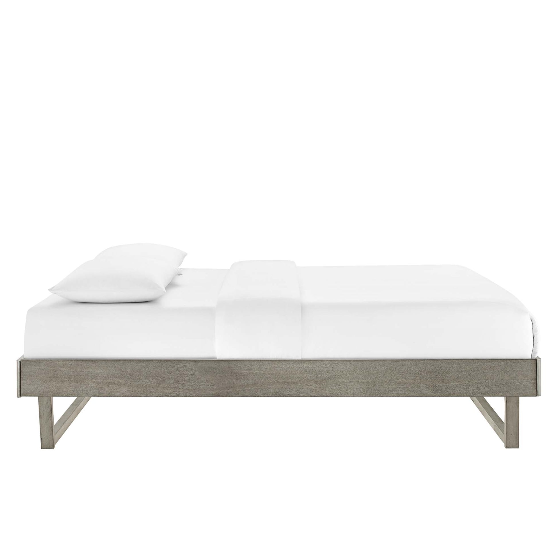 Low-profile gray wood platform bed with white bedding and pillow, minimalist modern design.