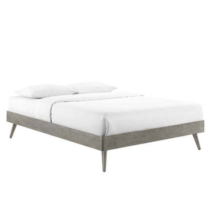 Grey wood platform bed with tapered legs and white bedding.