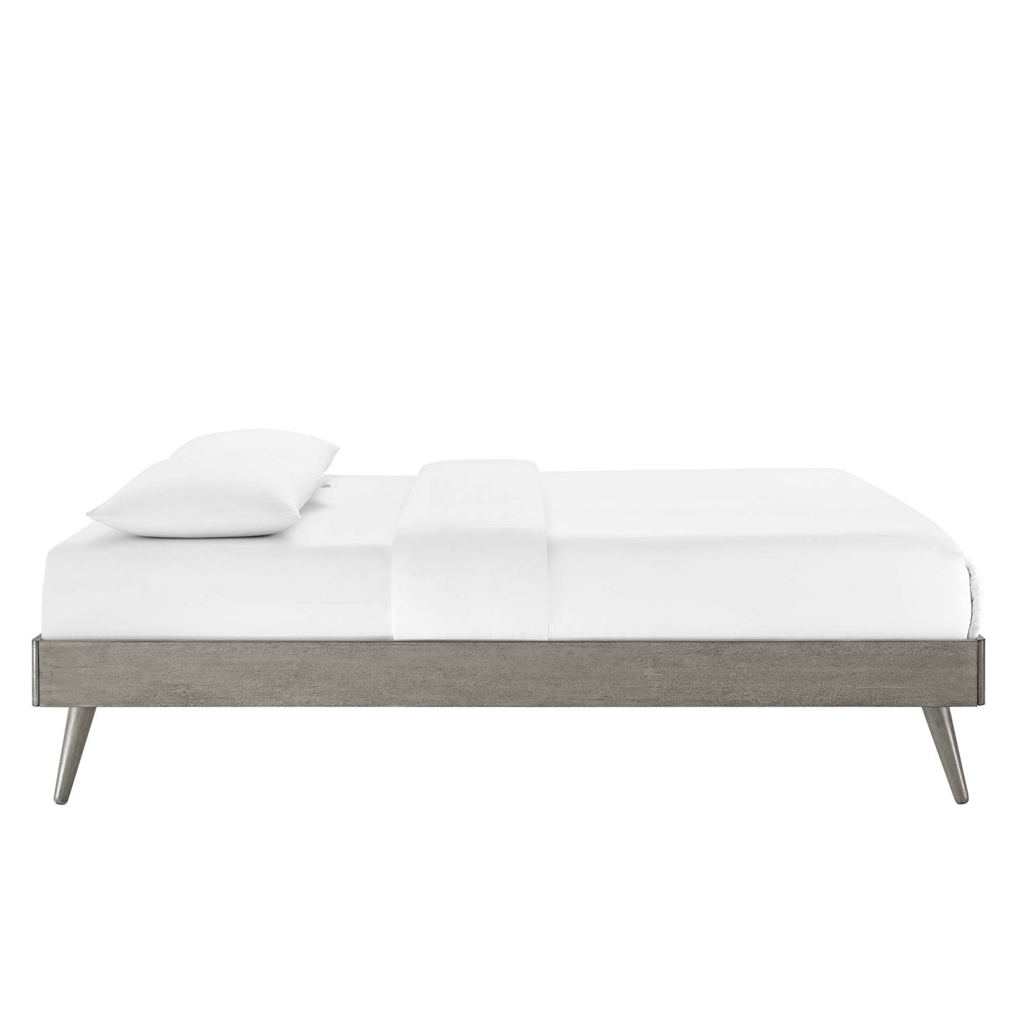 Modern low-profile platform bed in weathered gray wood with tapered legs and white bedding.