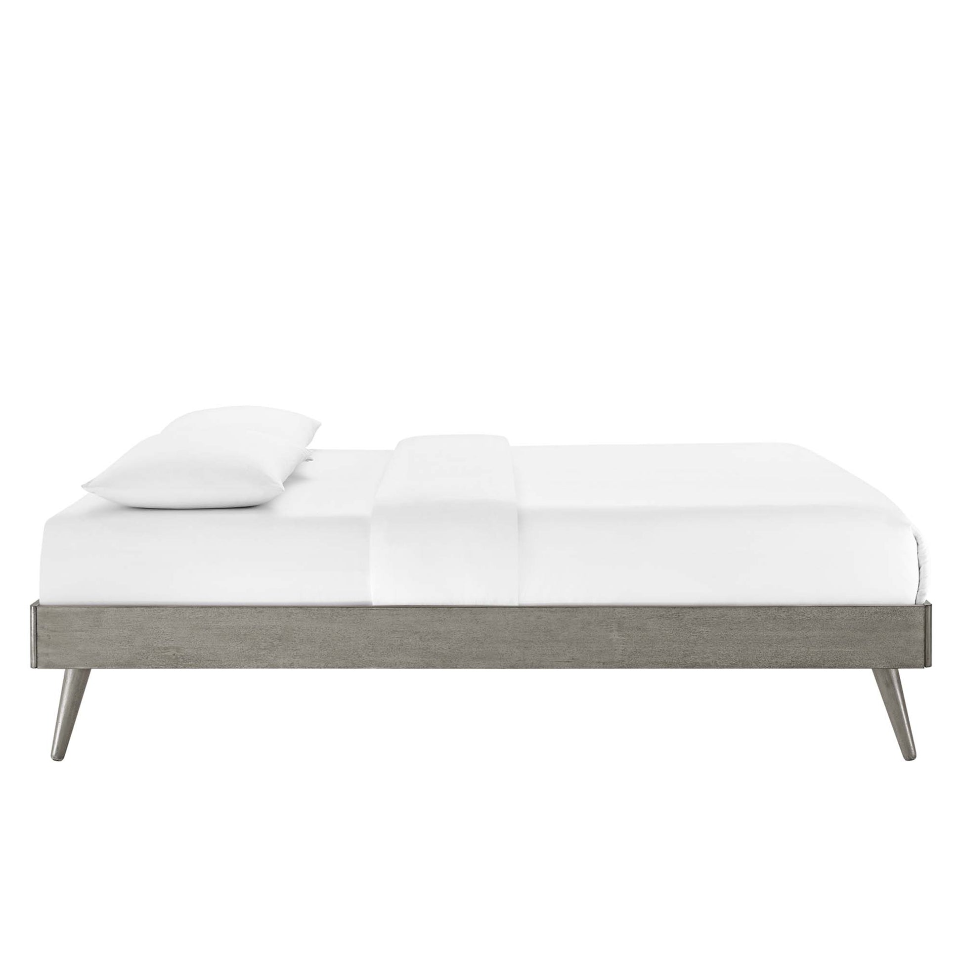 Modern low-profile platform bed in weathered gray wood with tapered legs and white bedding.