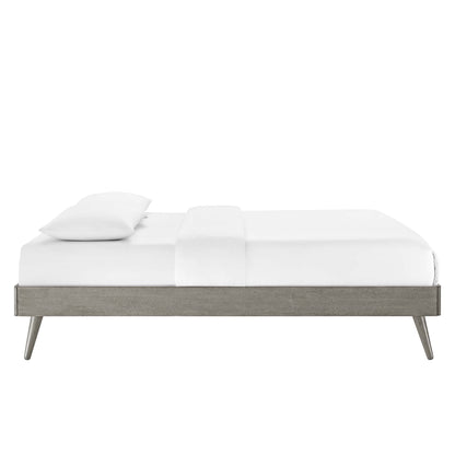 Modern low-profile platform bed in weathered gray wood with tapered legs and white bedding.