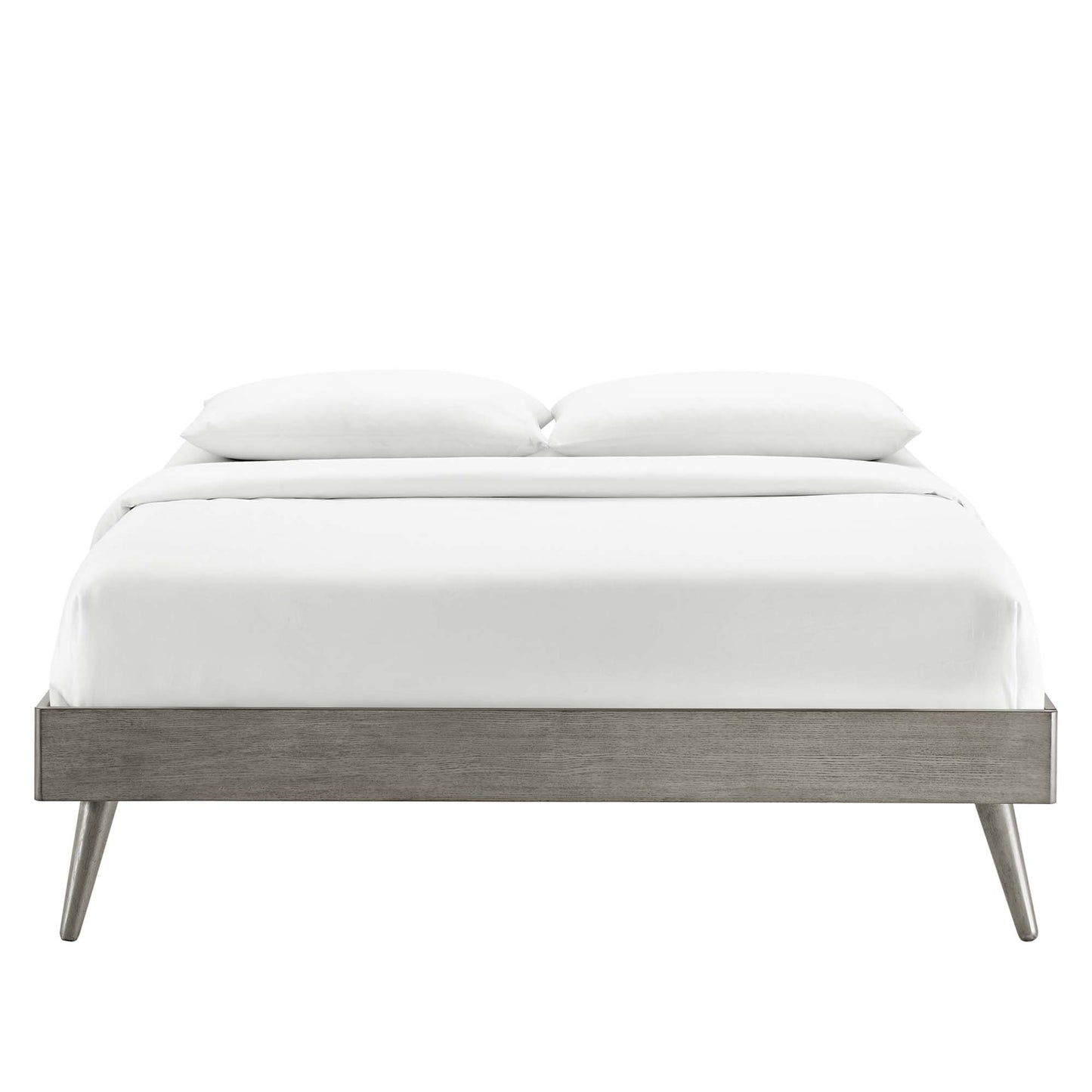 Gray wood platform bed frame with tapered legs in a mid-century modern design, dressed in white linens and two pillows.