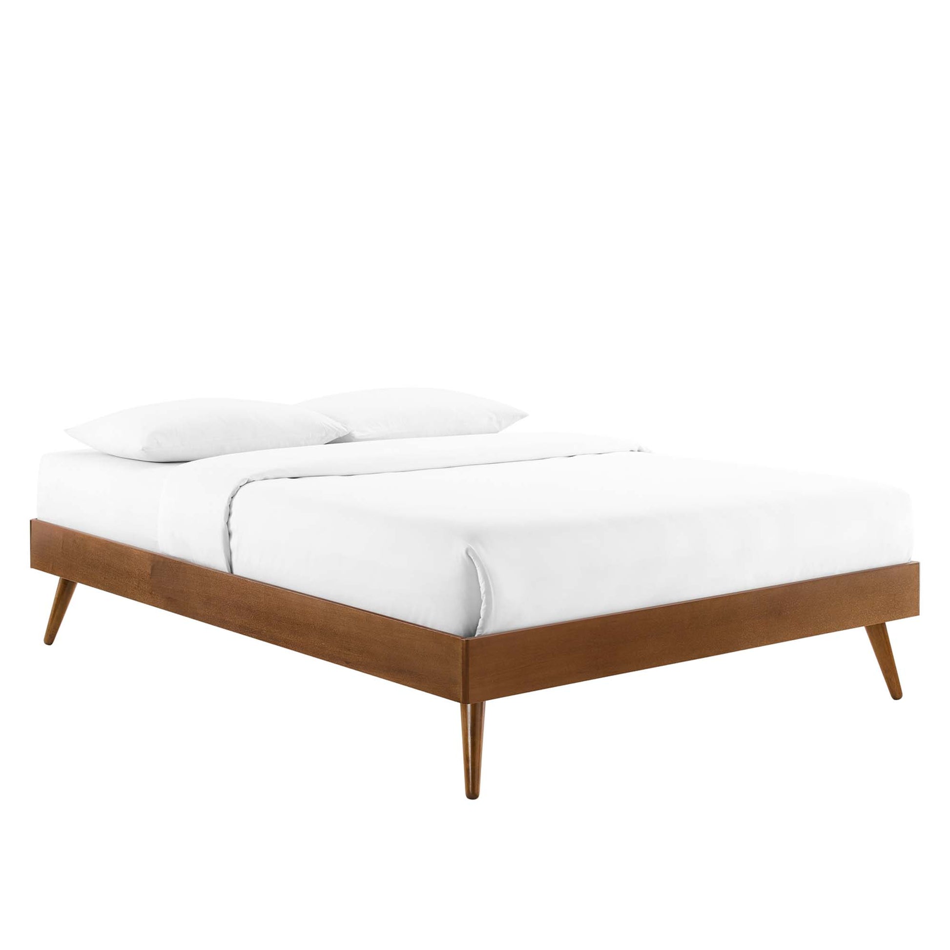 Walnut platform bed with tapered legs in mid-century style, dressed in white bedding with two pillows.